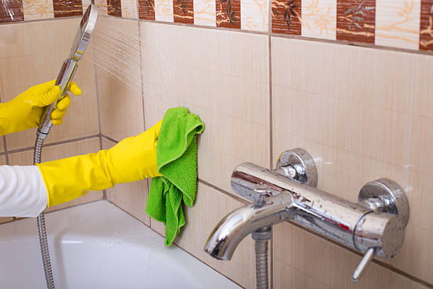 istock Woman cleaning tiles in bathroom 519388940