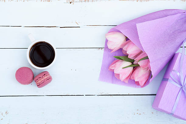 istock Pink tulips, gift, cup of coffee and macaroons 519389604