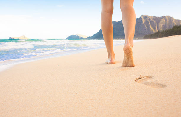 istock Woman walking on the beach 519390862