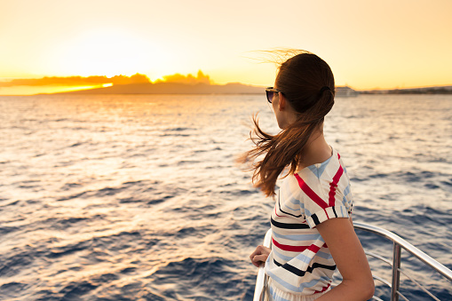 Woman on the cruise ship watching beautiful sunset.