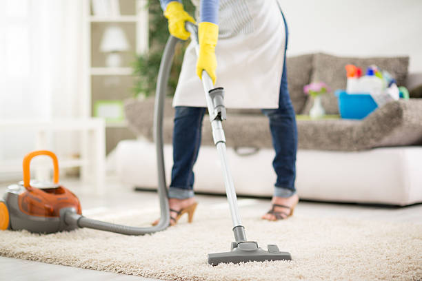 istock Woman clean carpet with vacuum cleaner 519391432