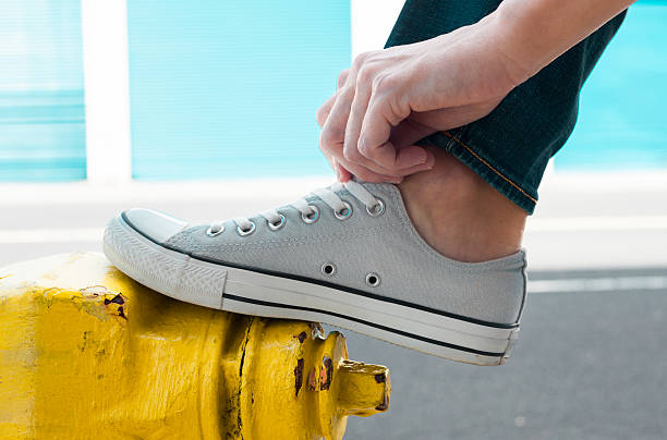 Person putting on pair of shoes. (Fashion concept)
