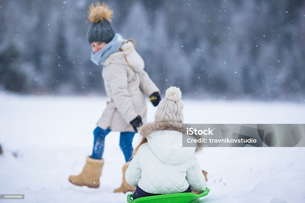 Poco encantadores niñas Disfrute de un paseo en trineo. Trineo con niños - Foto de stock de Actividad libre de derechos