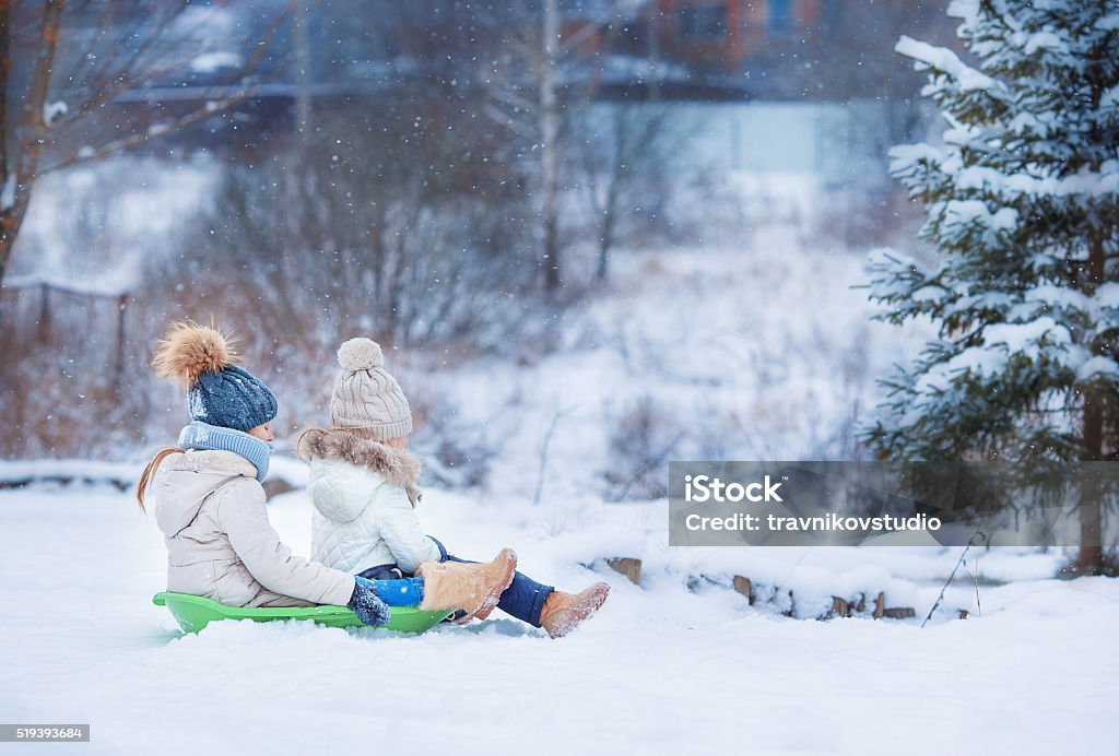 Encantadores poco feliz Chicas trineo con en invierno nívea día - Foto de stock de Actividad libre de derechos