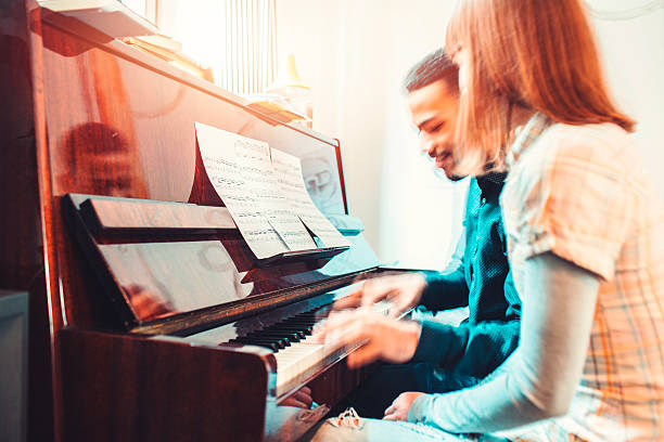 istock Young adults playing piano together 519394060