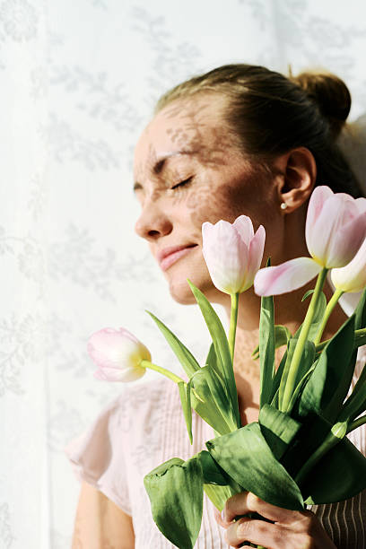 Young woman thinking of lover while she holding pink flowers