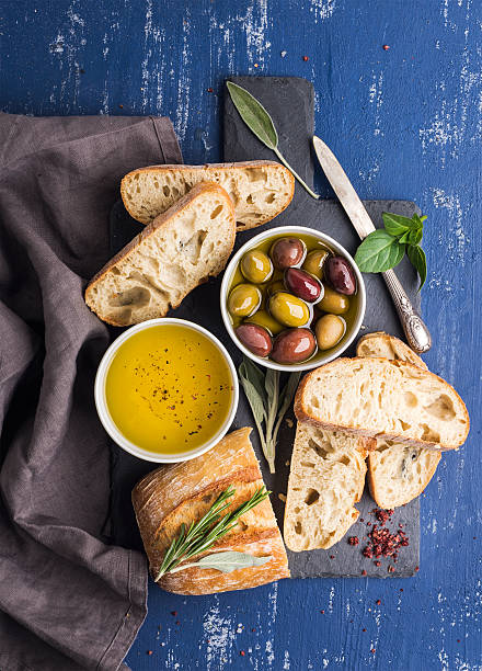 istock Mediterranean snacks set. Olives, oil, herbs and sliced ciabatta bread 519395098