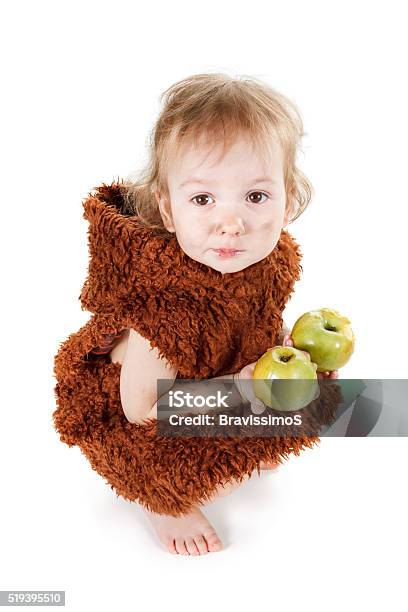 Little Funny Neanderthal Boy With Dirty Face Eating An Apple Stock Photo - Download Image Now