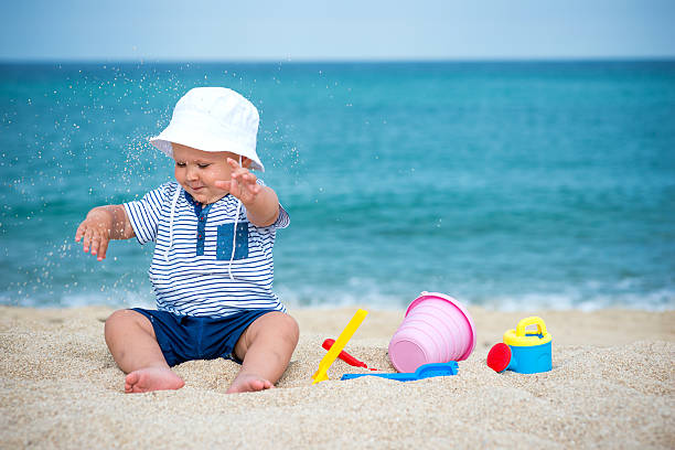 istock Cute baby on the tropical beach playing toys 519396064
