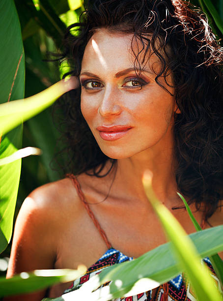 Middle Aged Brunette Elegant Woman With Green Leaf In Exotic Stock