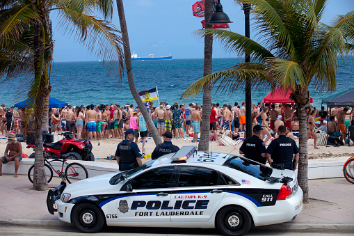 Fort Lauderdale, Florida, USA - March 14, 2016: Police watching over students having a good time in Fort Lauderdale, Florida during spring break. Fort Lauderdale is a major vacation destination for college students during spring break and security and safity are a major concern for local communities.
