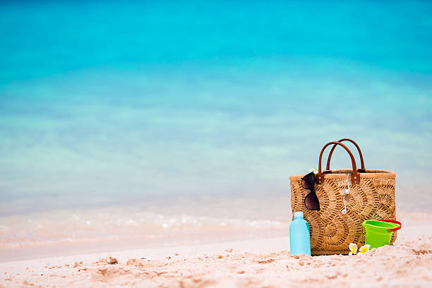 istock Beach accessories - bag, straw hat, sunglasses on white beach 519400416