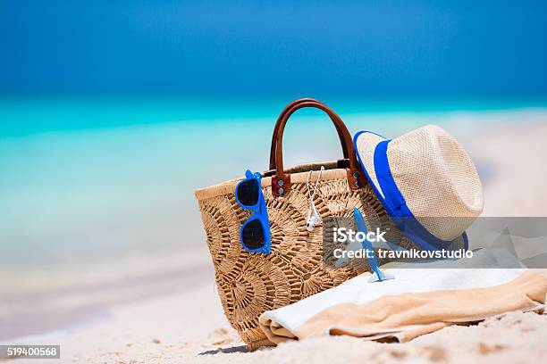 Beach Accessories Bag Straw Hat Sunglasses On White Beach Stock Photo - Download Image Now
