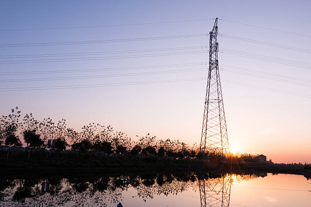 istock Electricity voltage transmission tower by the lake in sunset. 519403413