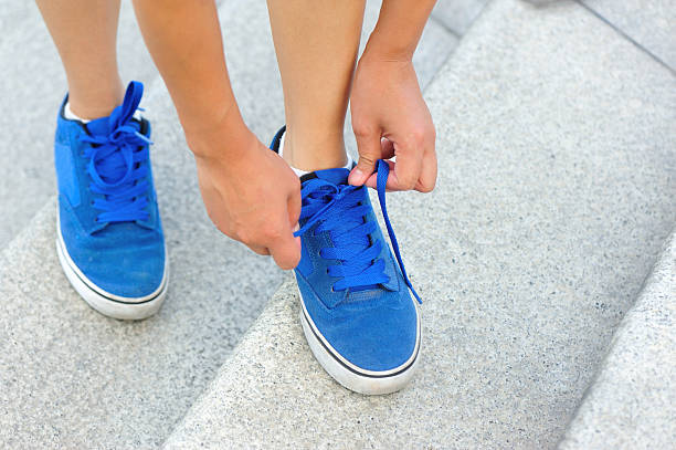 istock woman runner/ skateboarder tying  shoelace 519404875
