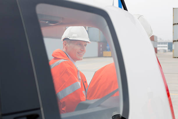 istock Engineers conversing beside car in shipping yard 519406985