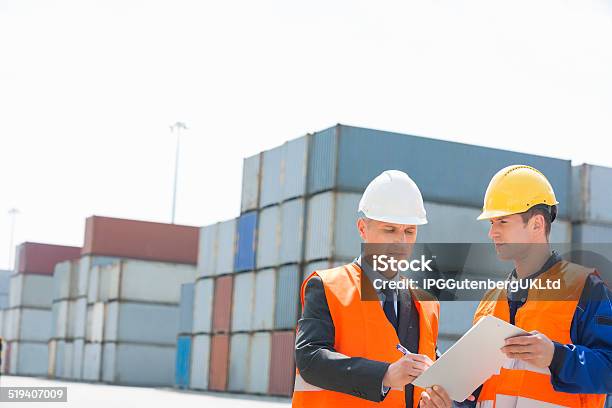 Worker Taking Sign Of Supervisor On Clipboard In Shipping Yard Stock Photo - Download Image Now