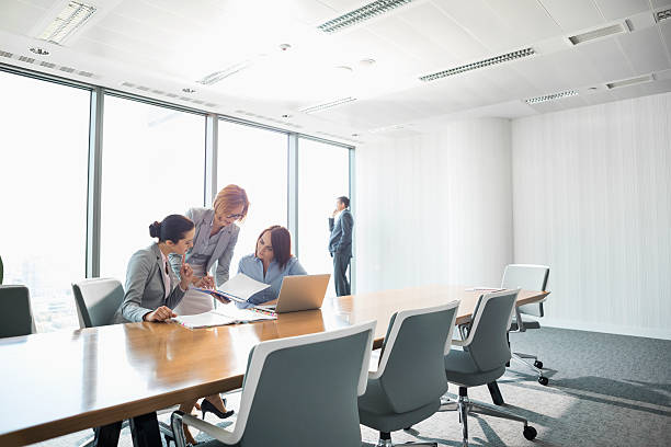 istock Businesswomen looking at documents in conference meeting 519407055