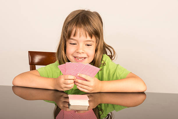 portrait of smiling little girl playing cards