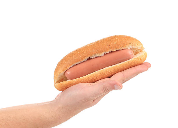 Hot dog with sausage roll in hand.