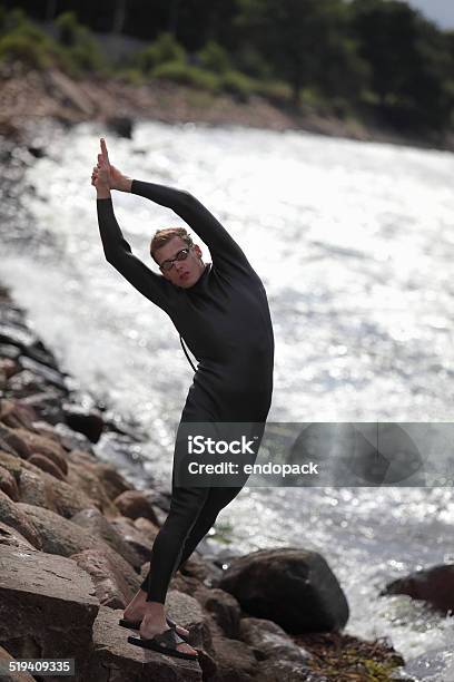 Young Athlete On Rocky Beach Prepearing To Swim Stock Photo - Download Image Now - Beach, Triathlon, Activity