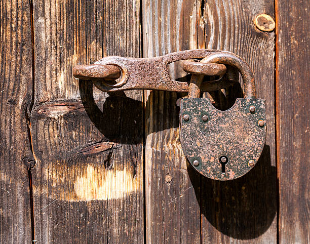 istock Rusty padlock on an old wooden door 519409569