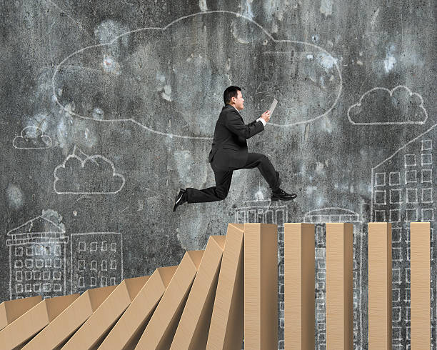 istock Man using digital tablet running on falling wooden dominos 519420810