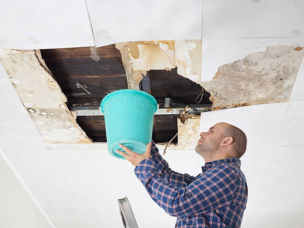 homem recolher água no balde de tecto - roof leak imagens e fotografias de stock