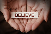 Believe text on hand
