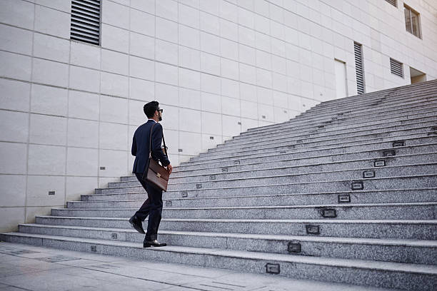 Businessman on stairs Business executive with briefcase going up the stairs steps and staircases stock pictures, royalty-free photos & images