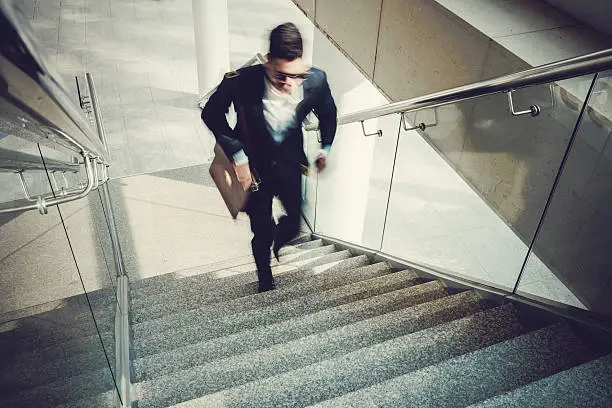 Blurred motion of businessman going upstairs in office building
