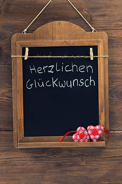 deutsche text herzlichen glueckwunsch bedeutet besten wünschen - heart shape textile button hanging stock-fotos und bilder
