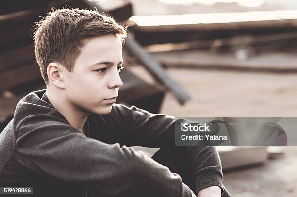 Pensive Teenager Sitting On The Roof Of The House Stock Photo - Download Image Now - Adolescence, Beautiful People, Beauty