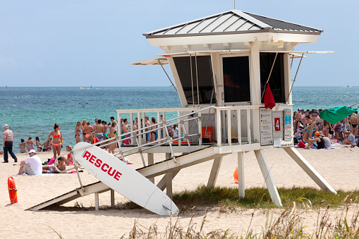 Fort Lauderdale, Florida, USA - March 14, 2016: Modern lifeguard with lots of  students in the background celebrating spring break in Fort Lauderdale, Florida