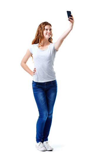 Studio shot of an attractive young woman taking a selfie with her mobile phone