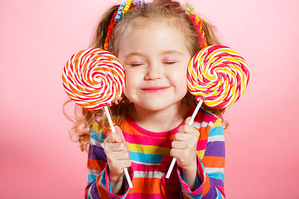 hermosa niña con piruleta - rizitos fotografías e imágenes de stock