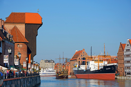 Gdansk, Poland - October 4th, 2014: Motlawa river in old town. On the left - the waterfront with the famous Gdansk Crane. On the right - the Granary  Isle and the ship \