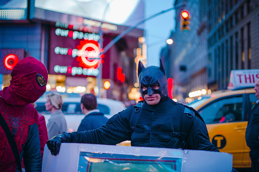 New York City, USA - April 19, 2013:  Men in Batman and Spiderman costumes at Times Square at evening