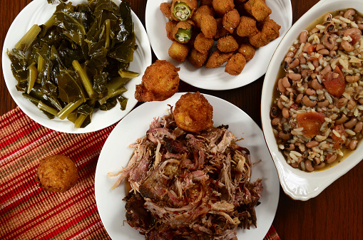 Barbecued pulled pork with collard greens, hush puppies, fried okra, and hoppin' john, a dish often eaten on New Year's Day for good luck.