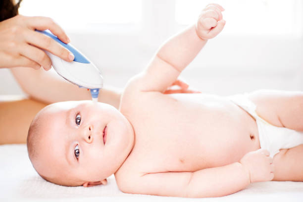 istock Mother taking ear temperature of baby 519441481