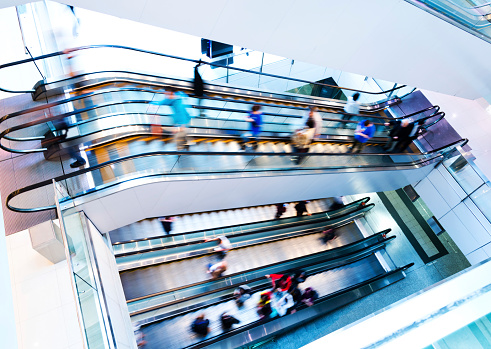 People in motion in escalators at the modern shopping mall.