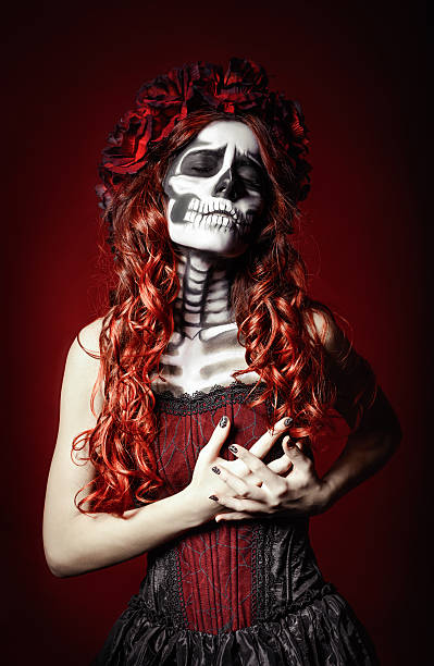 Sad woman with muertos makeup (sugar skull) holding her chest