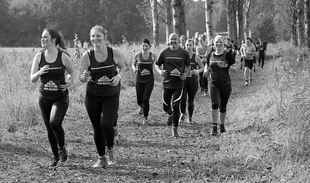 grupo de participantes jogging ao ar livre na corrida na lama - individual event women people autumn imagens e fotografias de stock