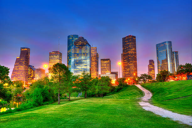 Houston Texas modern skyline at sunset twilight on park Houston Texas modern skyline at sunset twilight from park lawn HDRI houston skyline stock pictures, royalty-free photos & images