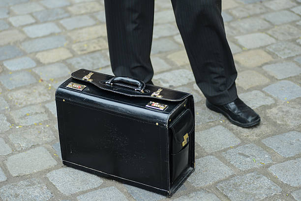 istock black suitcase on street next to businessman 519461289
