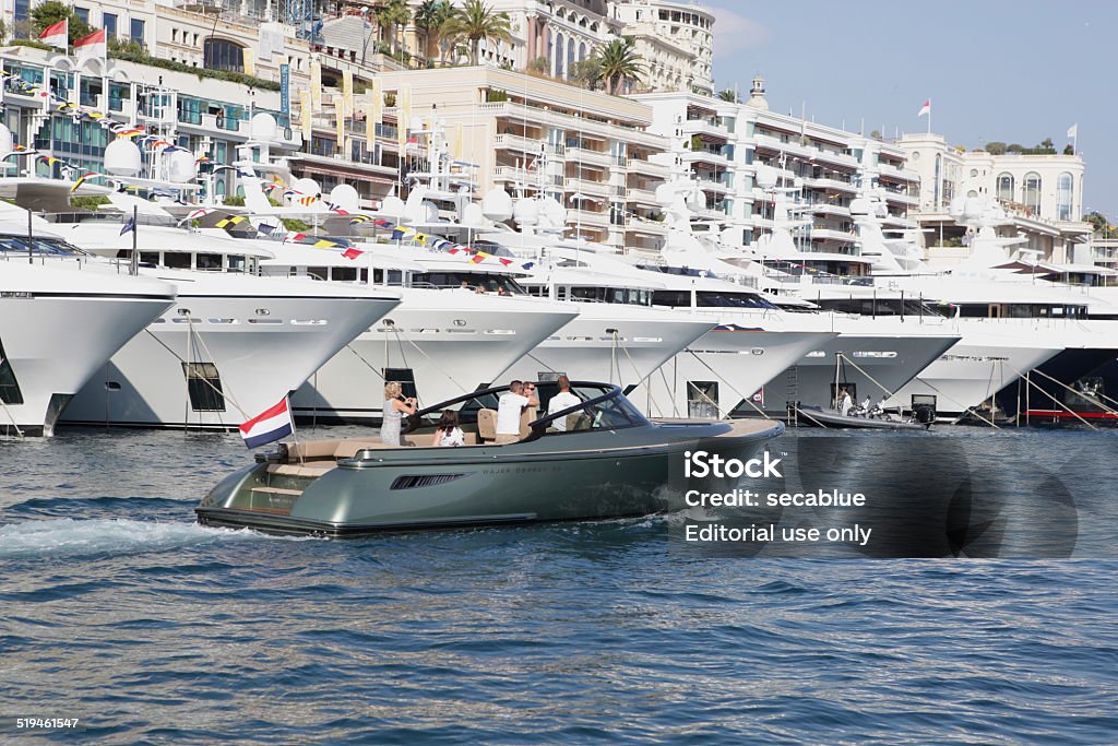 Large and small yachts, Monaco Monaco, Monaco - September 25, 2014: People use the smaller tender boats to view the 2014 Monaco Yacht Show in Port Hercules. Day Stock Photo
