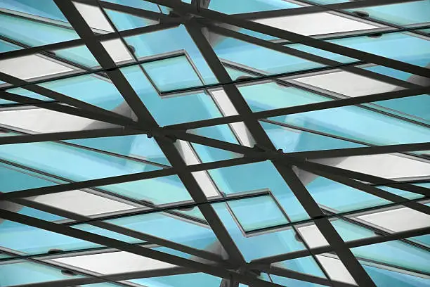 Fragment of office building roof / ceiling, a glazed aluminum structure with triangular pattern. Abstract architectural background composition.