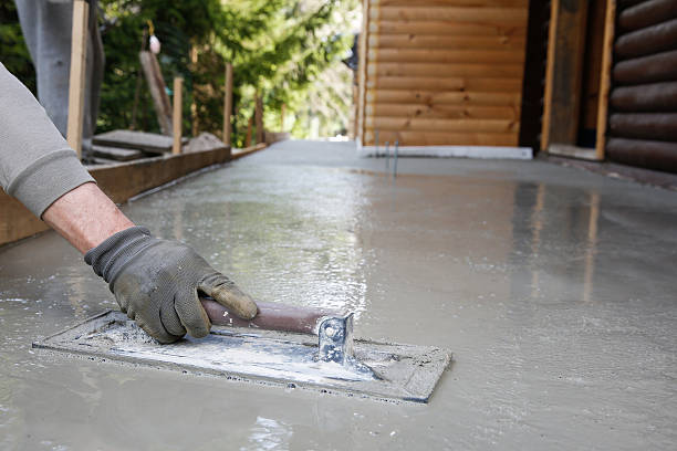 Mason leveling and screeding concrete floor base Mason leveling and screeding concrete floor base with square trowel in front of the house. Construction business, do-it-yourself, precision work around the house concept. concrete work stock pictures, royalty-free photos & images