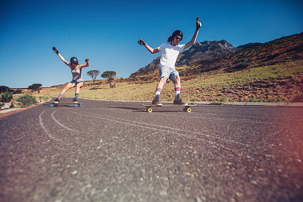 istock Young couple skateboarding on the road 519469210