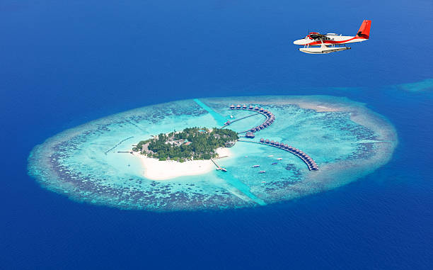 aeroplano volando sopra il mare isole delle maldive - isole maldive foto e immagini stock